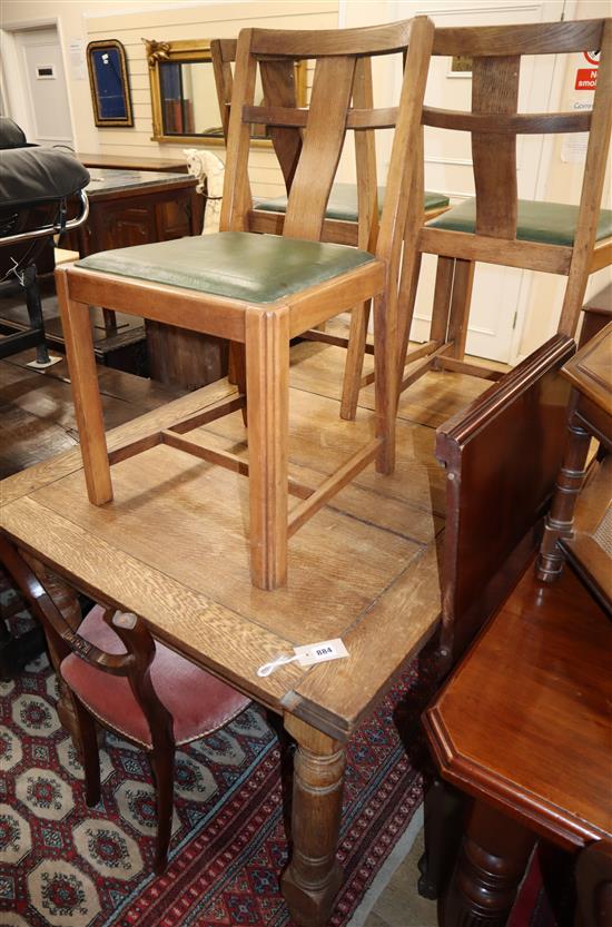 A 1920s oak draw leaf dining table and four chairs table 230cm extended
